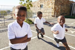 Young African schoolboys running in school playground
